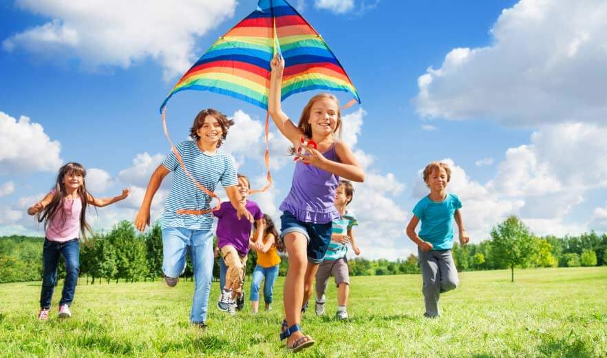 Viele Kinder lassen auf einer Wiese einen Drachen steigen